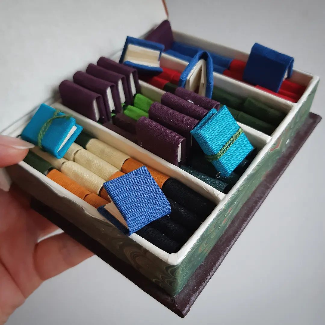 Like a chocolate box, only better. Ties to be added to these, then they are ready for the @imc_leeds craft fair on the 6-7th July.

[Image description: a small box held open to reveal rows of tiny book charms in different colours.]

#TinyBooks #MiniatureBooks #WorkInProgress #Batchmaking