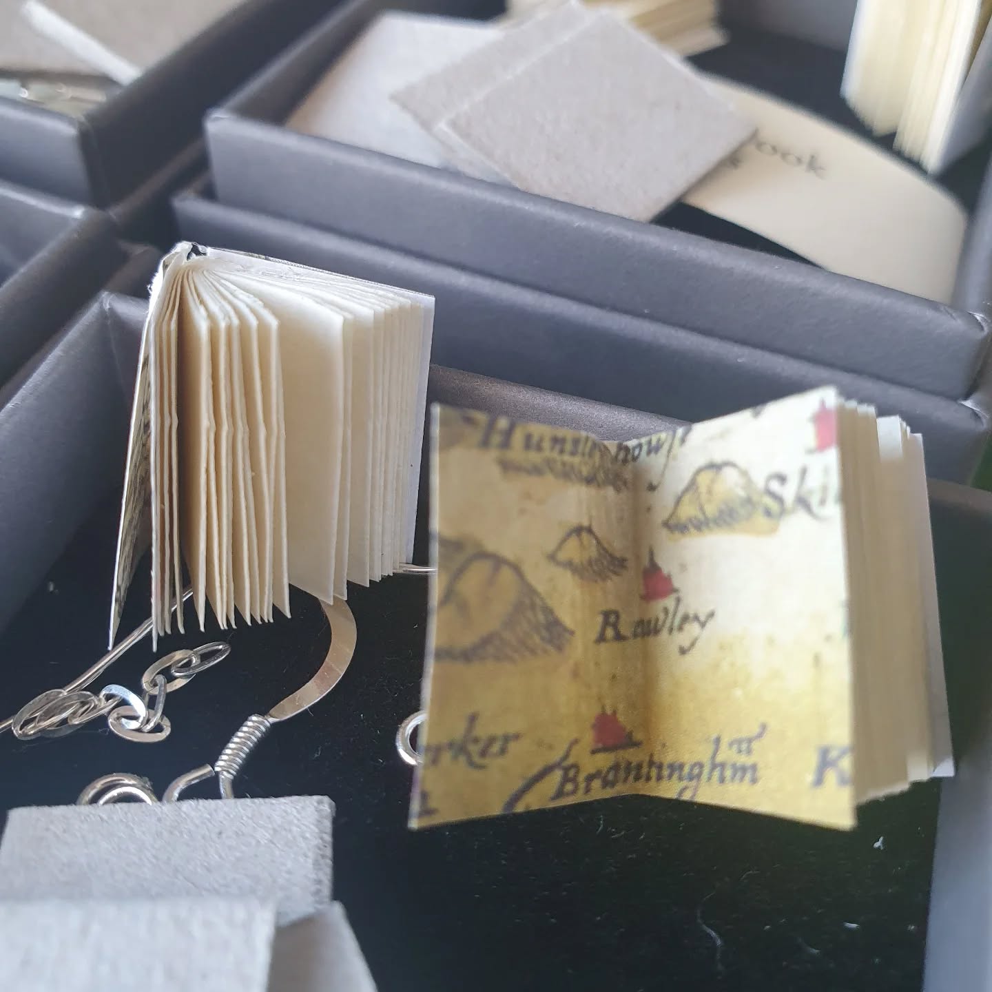 All the tiny books now have tiny Yorkshire map endpapers. "Just" the cases to make and casing in to go. Getting there.

[Image description: some tiny text blocks sitting in a jewellery box]
