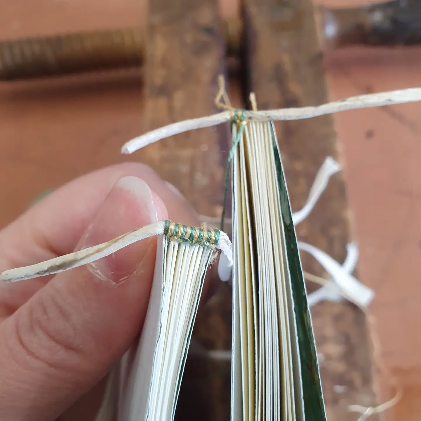 Getting back into the swing of things post class with some teeny endbands. An unusual front bead for me this week as I'm working on some more modern bindings.

[Image description: two books, one with a finished ebdband, one in progress.]