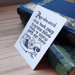 A bookplate that reads "Any who steal this book away may rats follow them and ravens peck out their eyes." with a decorative ribbon for writing your name and raven marginalia.