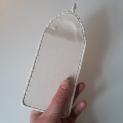 A hand holding a leather folded almanac