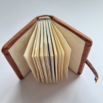 a miniature medieval style book showing the blank pages and endband