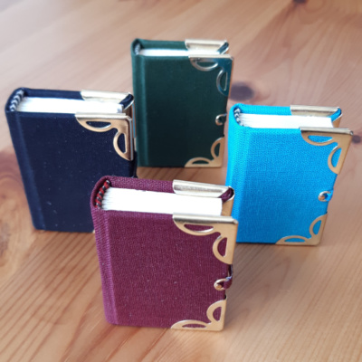 Four miniature books with gold corners and clasps