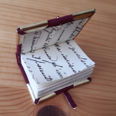 a miniature book with handwriting sample endpapers