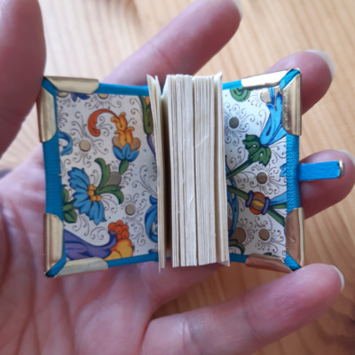 a miniature book with medieval style foliage endpapers