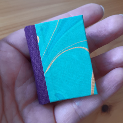 Miniature book in purple and green