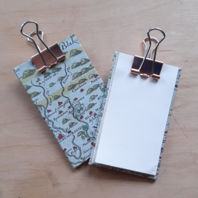 Two miniature clip boards one showing the yorkshire map cover, the other showing pages held in the clip. Both have rose gold clips.