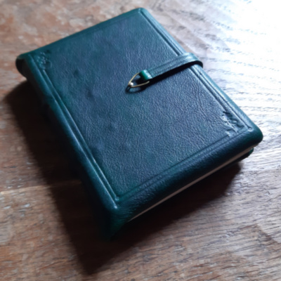 A green leather book showing the detail of the blind tooling.