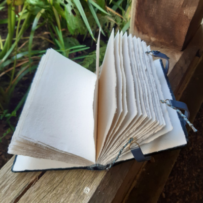 A book open to show the handmade rag paper pages.