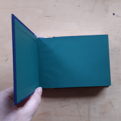 A book held open to show green endpapers.