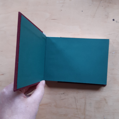 A book held open to show green endpapers.