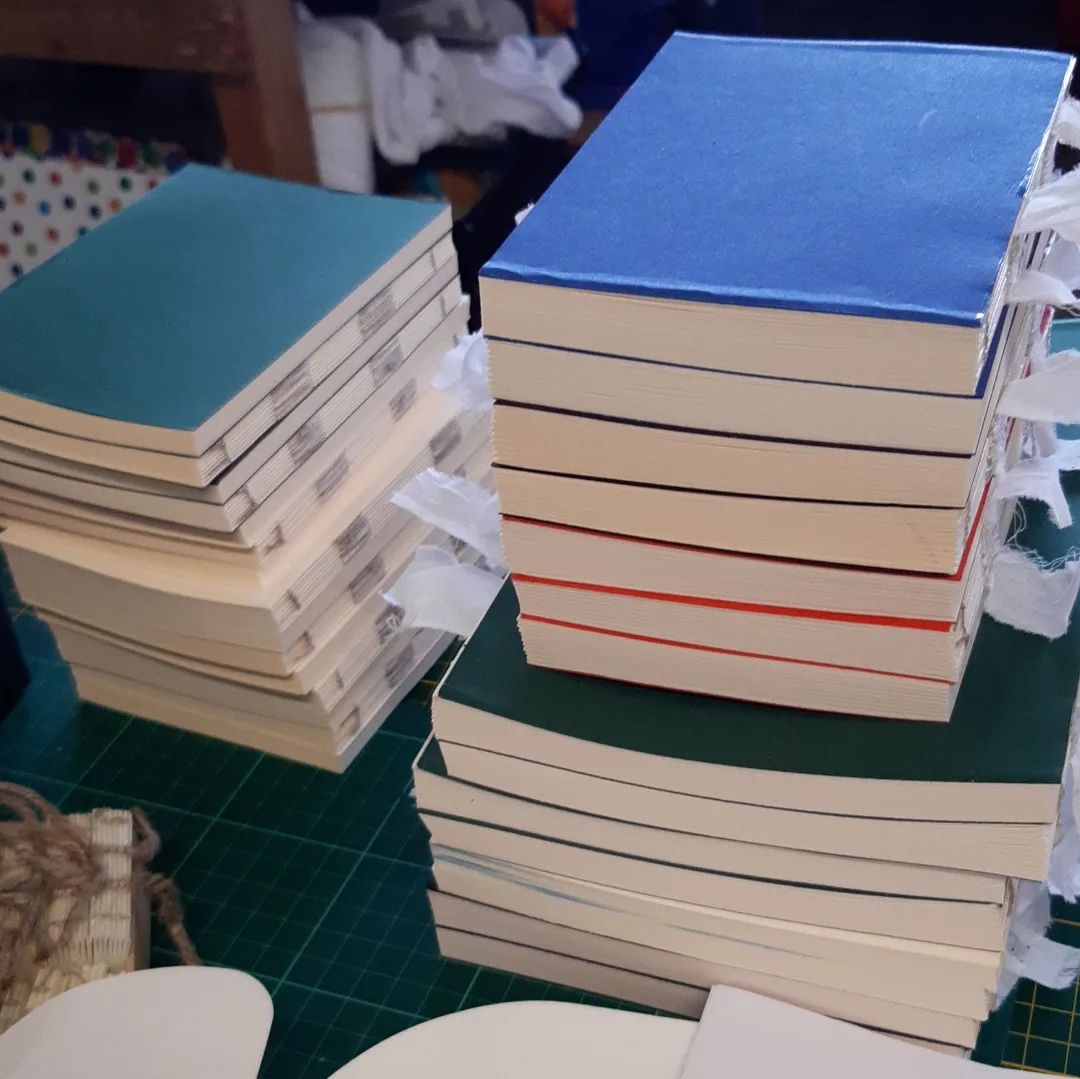 Another stack joins the first, all now trimmed and ready for spinelinings and covers. This is the stage I discovered I had lost the power to count yesterday while sewing and folding as I'm 1 book short of what I was expecting. A pleasing pile nonetheless.

[Image description: a pile of textblocks, sewn, trimmed and with endpapers attached, stacked in two stacks on a workbench.]

#BatchMaking #IMCLeeds2022 #WorkInProgress