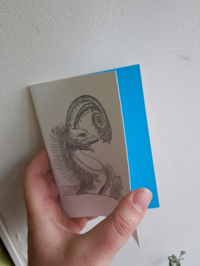 a notebook with a sea monster wood cut image on the cover.