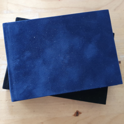A dark blue landscape suedette covered book.