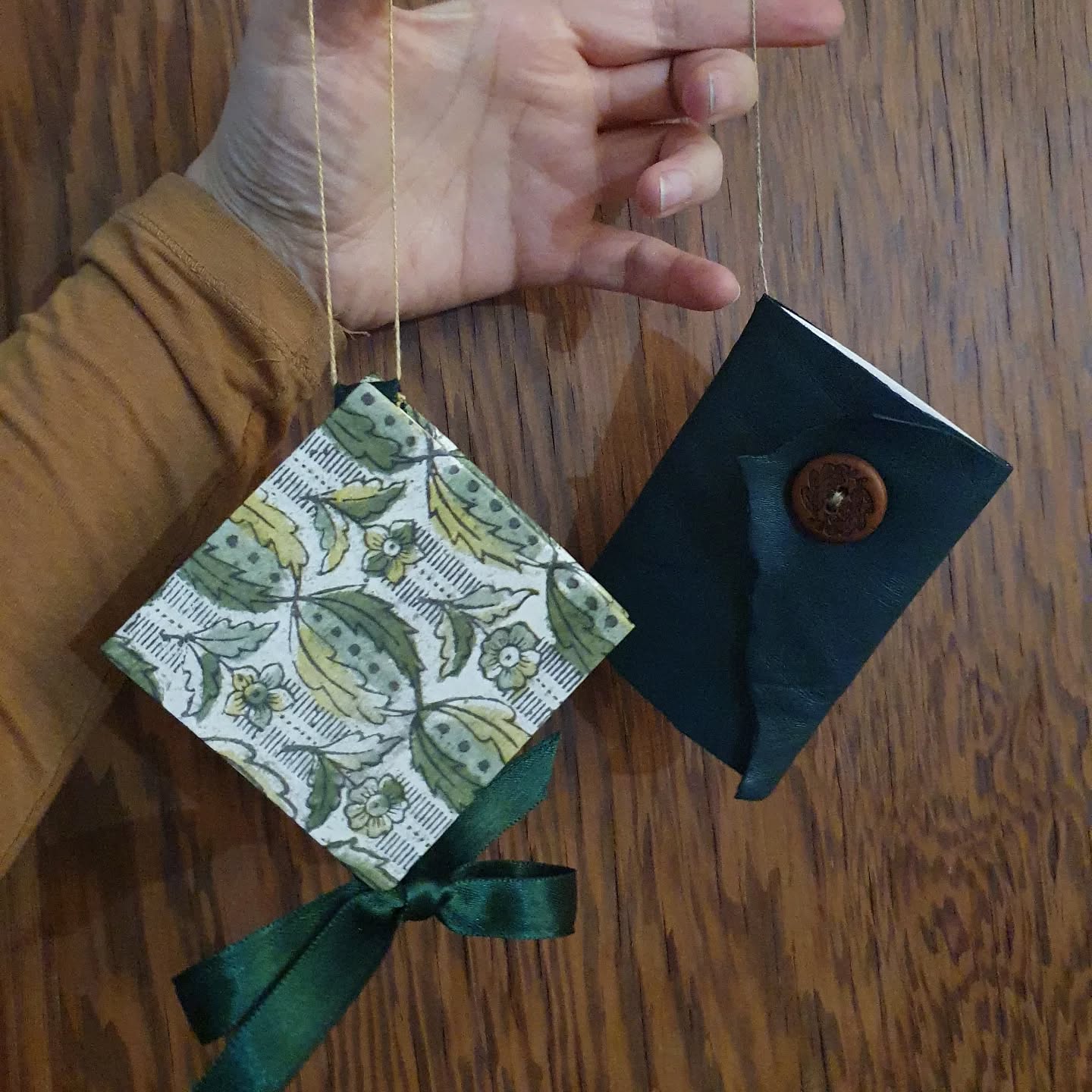 Save the date! Working on something very exciting coming this Thursday 11th and next on the 18th in Leeds. Keep an eye on here for more information coming very soon.
Pictured are my two book themed Christmas decorations that you can now go see in @yorkminsterofficial Christmas tree trail.

[Image description: a hand holding two hanging book decorations. One is diamond shaped and closes with a ribbon, the other a leather book that closes with an oak leaf decorated button.]