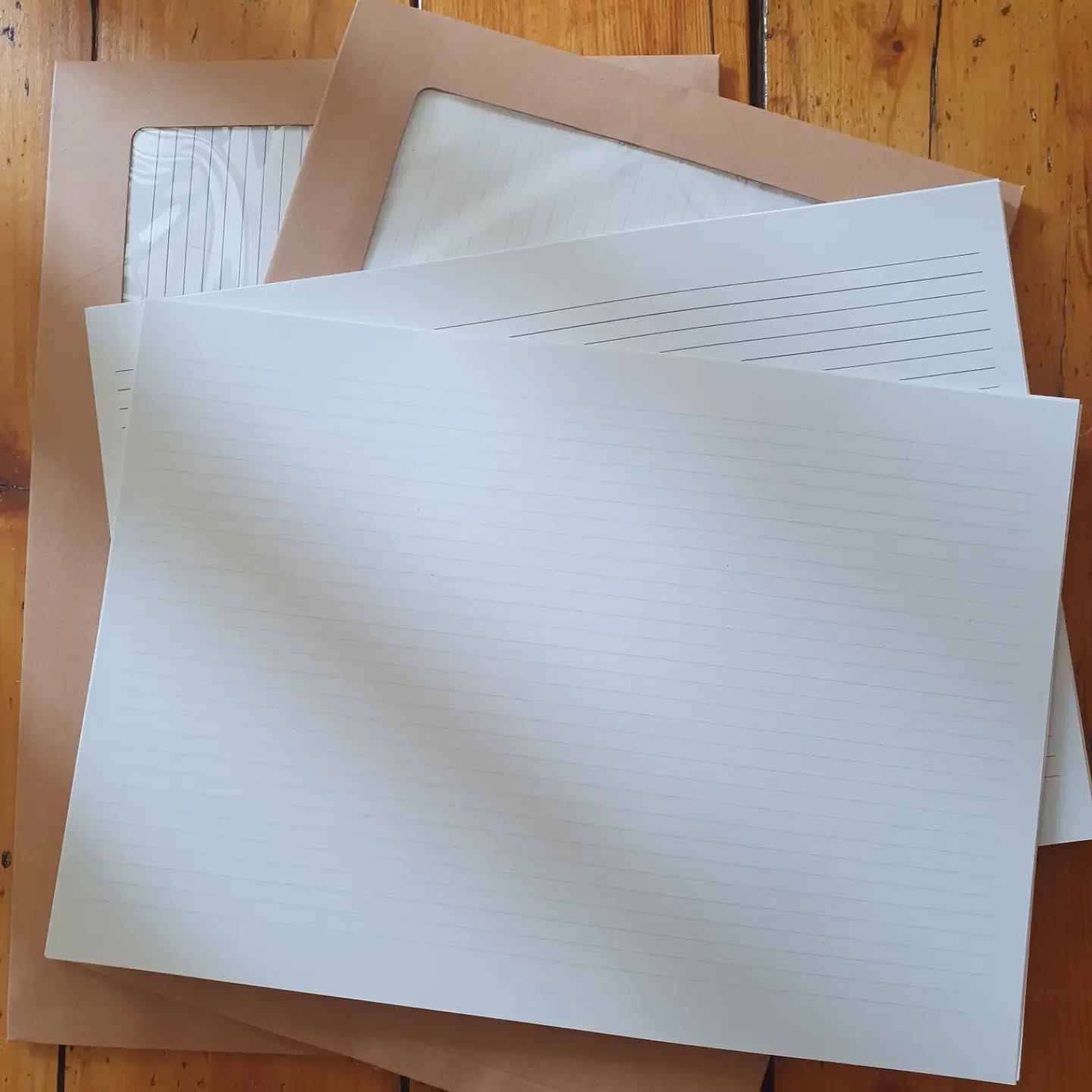 Preparation for the @sobbookbinders Conference in York this weekend. Some blue feint and rainbow lined A4 shortgrain ready to bind pages. I won't have many as it's a new venture for me. Dotted pages to print next.

[Image description: two envelopes with lined pages and two stacks of lined pages on a wooden background. One has pale blue lines, one has rainbow lines.]