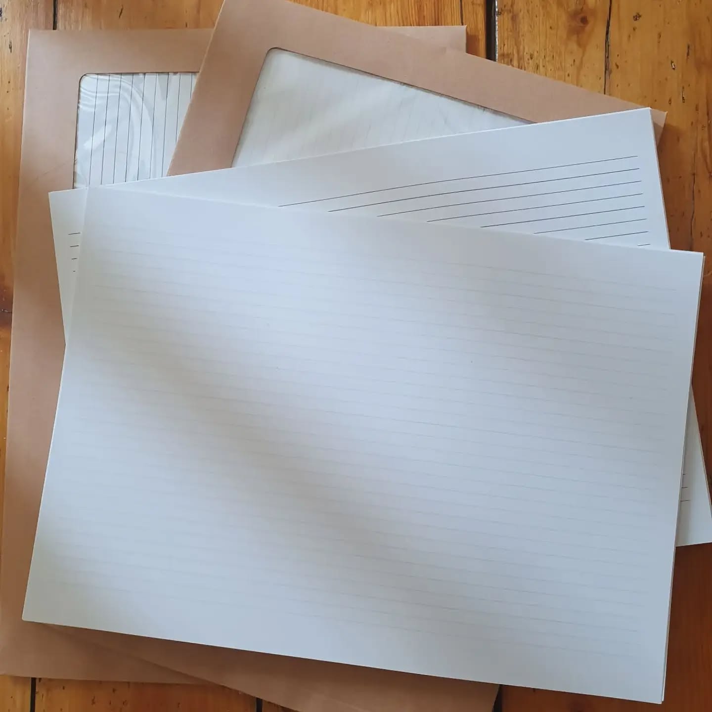 Now available in @fabricationcrafts Leeds Briggate and York Stonegate, ready to bind A4 papers, perfect for making A5 books. Printed with lines, rainbow lines, dotted squares, or staves. Limited runs. 

[Image description: packs of paper with stacks of unpackaged lined paper.]